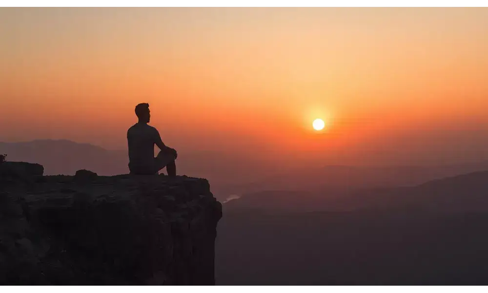 A peaceful man watching sunrise symbolizing self awareness and inner peace